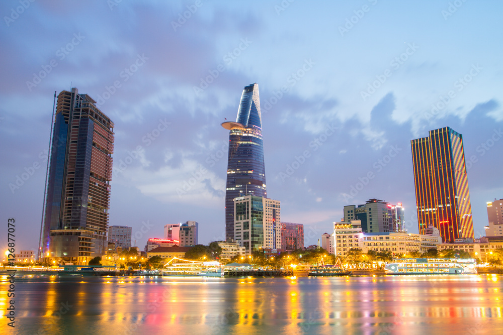 Obraz premium Night view of Downtown center of Ho Chi Minh city on Saigon riverbank in twilight, Vietnam.