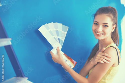 Young beautiful woman holding palette with collor samples
