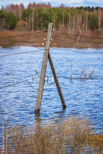 The electricity poles in the water. Flood - the river Mologa.