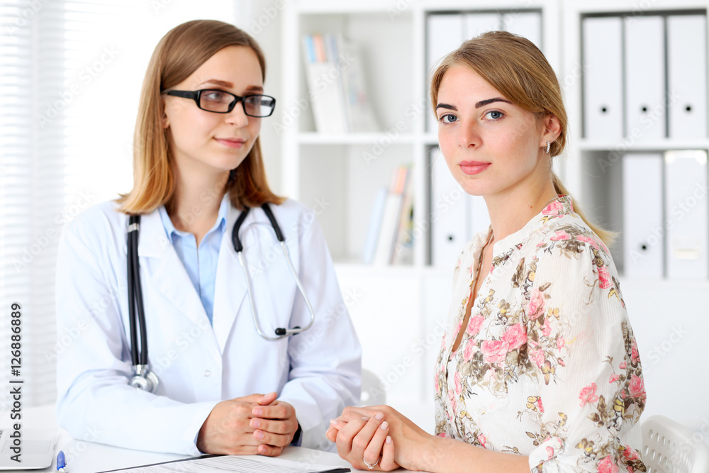 Doctor and patient sitting at the desk Doctor and patient sitting at the desk