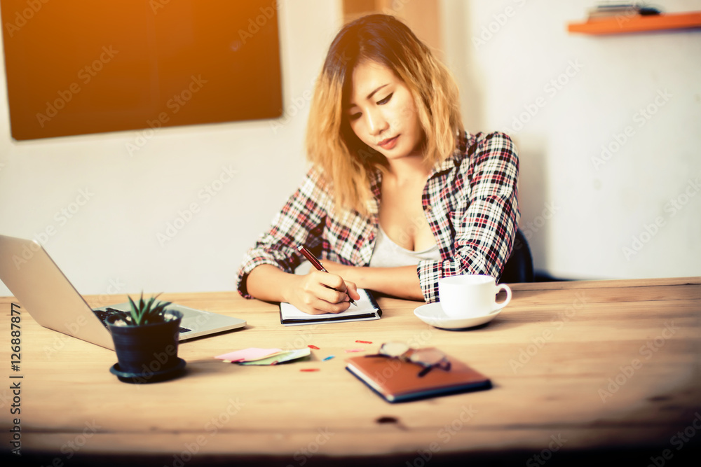 business woman writing something on notepad in office. business woman writing something on notepad in office.