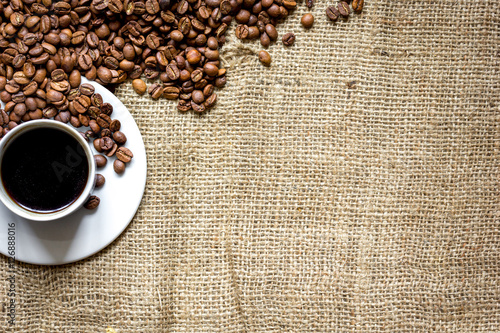 coffee beans, coffe cup on linen cloth background top view