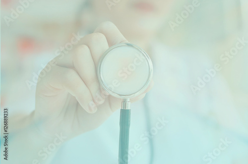 female doctor in white uniform holding stethoscope
