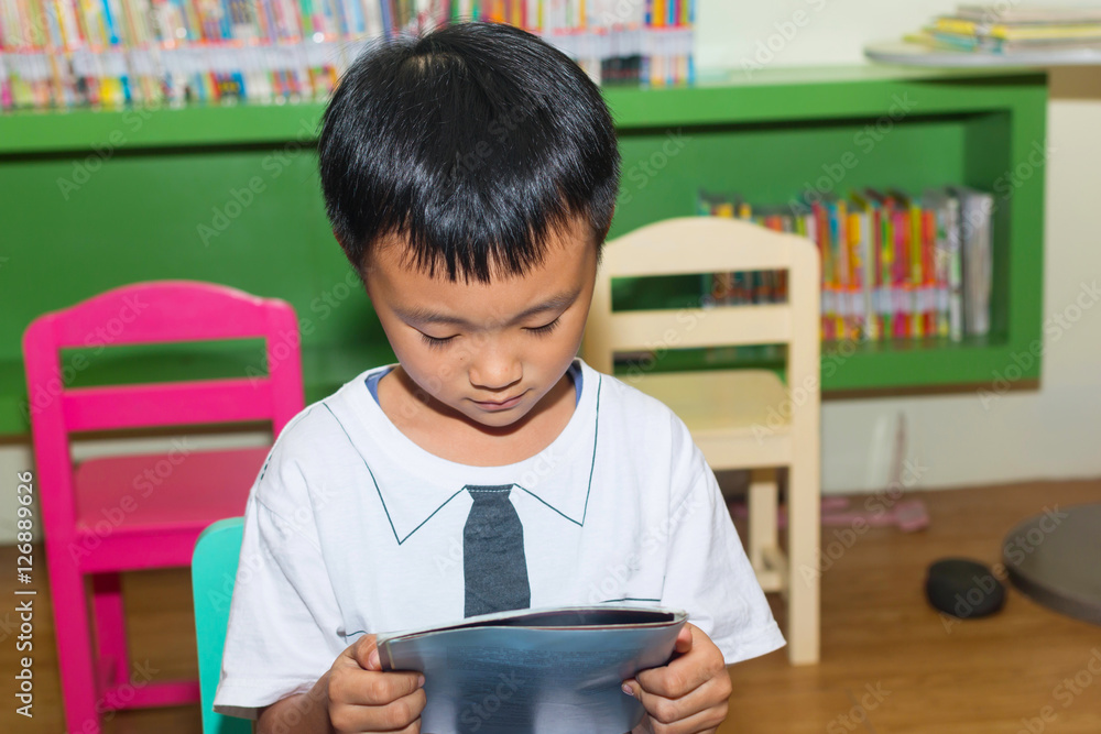 Cute little boy reading book in the library
Cute little boy reading book in the library