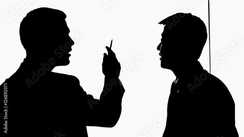 MS Silhouette of two businessmen talking and pointing to white board / China