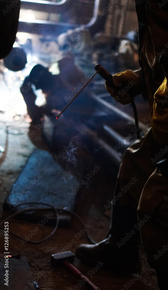 Workers welding pipes