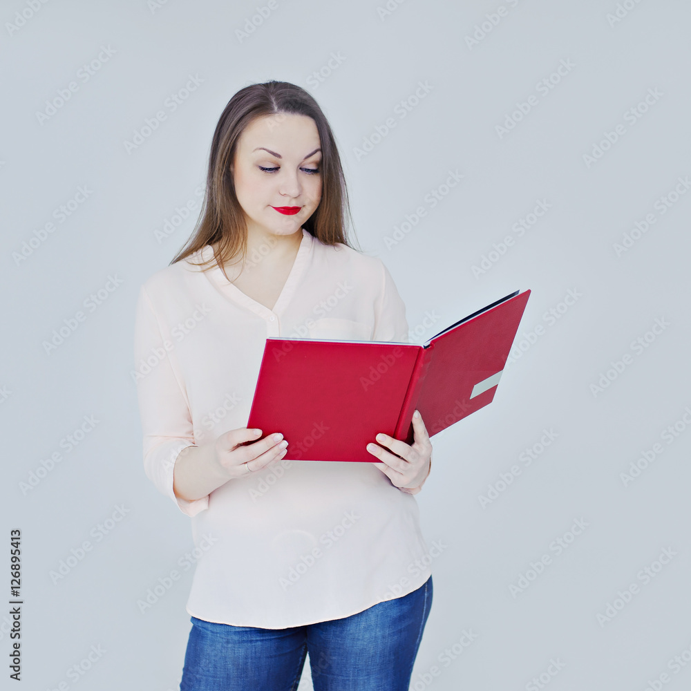 Young woman reading a book, gray background. Young woman reading a book, gray background.