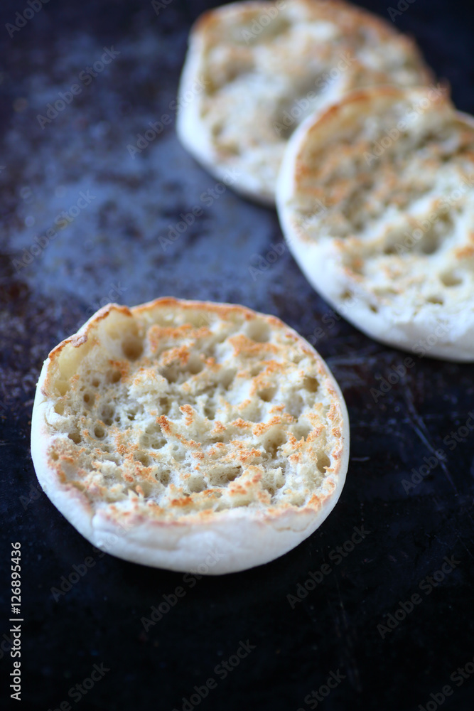 Toasted English muffins on an old metal surface