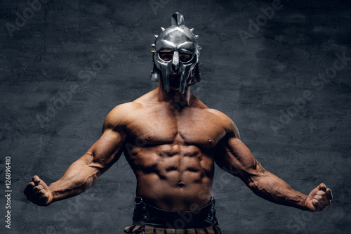 Muscular man in a gladiator silver helmet. photo
