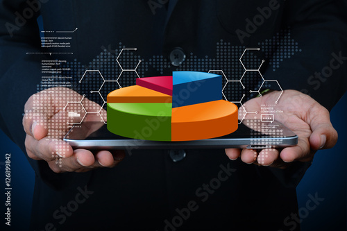 Business man showing pie chart with tablet computer in color background