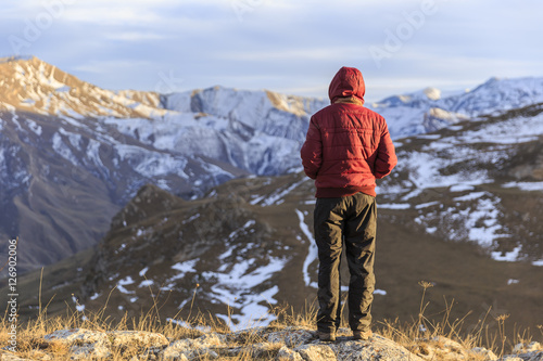 Young guy overlooks the mountainous surroundings of the village