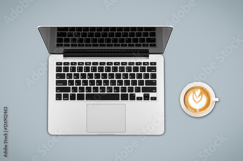 Top view laptop computer with cup of coffee on office desk table