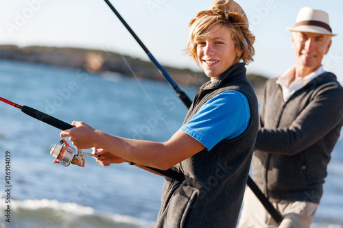 Senior man fishing with his grandson