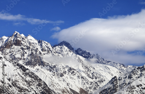 Snow winter mountains and blue sky with clouds at sun day