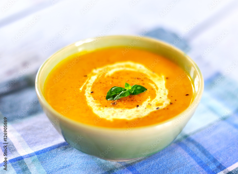 Bowl with pumpkin soup and copy space. Cream soup on a white wooden table. Bowl with pumpkin soup and copy space. Cream soup on a white wooden table.