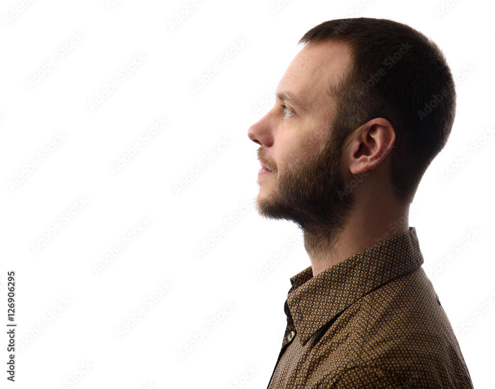 Obraz premium Side view of young bearded man isolated