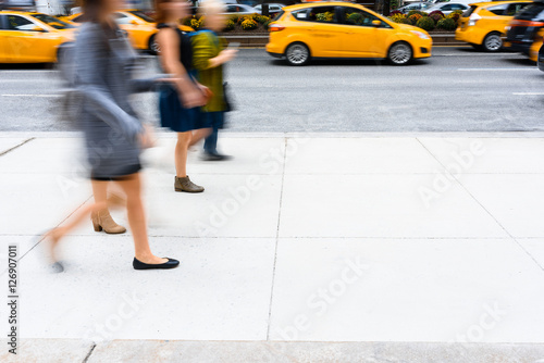 People walking down the street passing by taxi