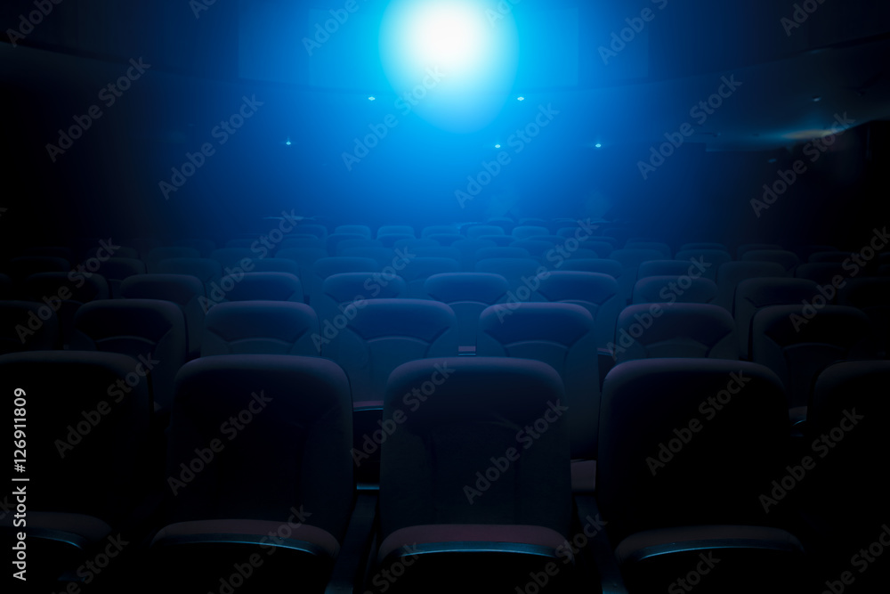Naklejka premium Dark film theater with projection light and empty seats