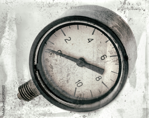 The old vintage measuring device with a scale from 0 to 10, and the arrow is stuck at zero. Stylised as aged old b&w photos. Industrial background.