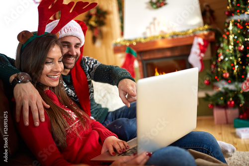 Man and woman at Christmas holiday with laptop