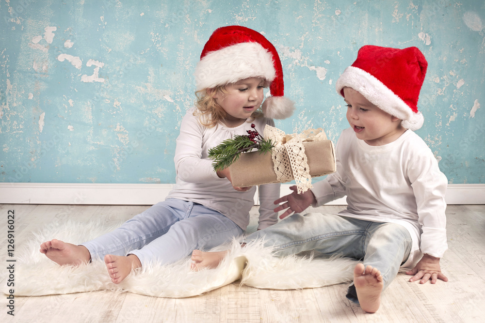 Obraz premium Vorfreude auf Weihnachten, Kinder mit Weihnachtsgeschenk