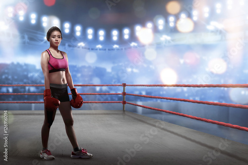 Sexy asian female boxer with boxing gloves standing in the boxing ring © Leo Lintang