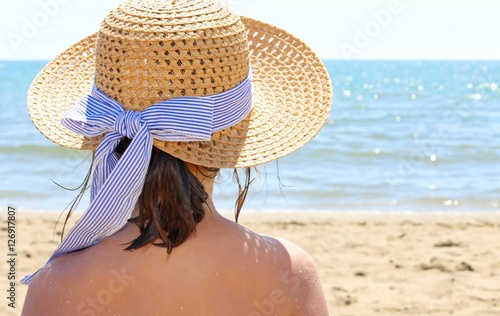 Young person with straw hat by the beautiful sea