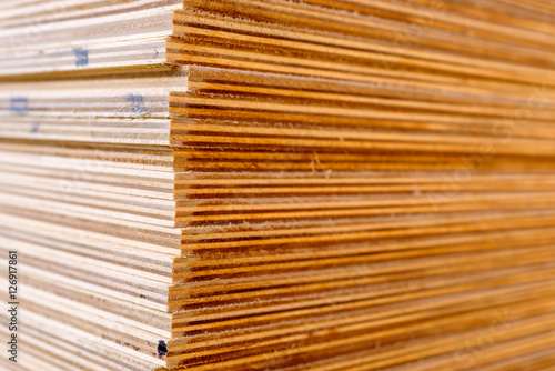 Sheets of stacked plywood in lumberyard. Shallow focus and blurred background. Copy space.