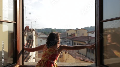 MH DS Woman Opening Windows Overlooking Old Town Rooftops / Florence, Italy