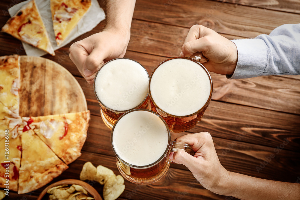People drinking beer and eating pizza in pub People drinking beer and eating pizza in pub