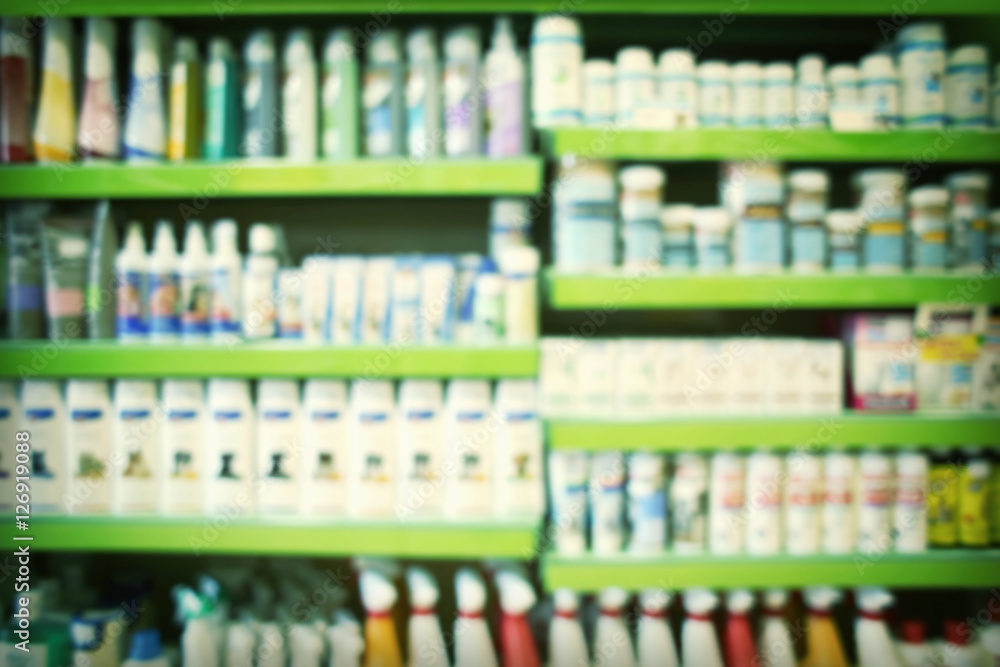 Blurred view of animal shampoos, vitamins and other goods on pet shop shelves