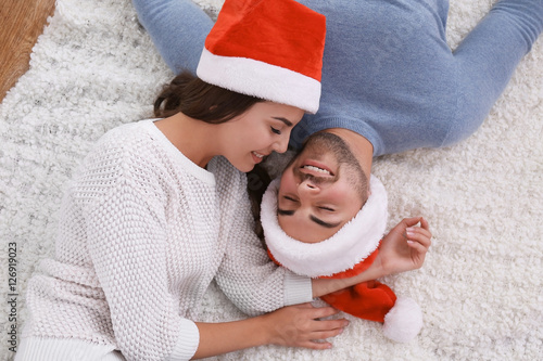 Young couple in Santa hats ...