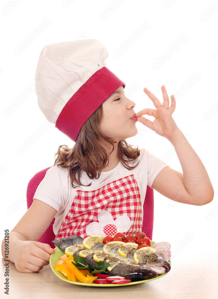 happy little girl cook with trout fish and ok hand sign happy little girl cook with trout fish and ok hand sign