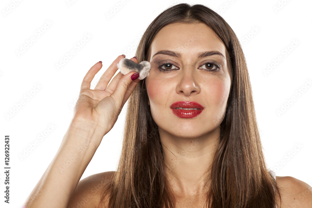 young woman shows a dirty piece of cotton from cleaning her makeup young woman shows a dirty piece of cotton from cleaning her makeup