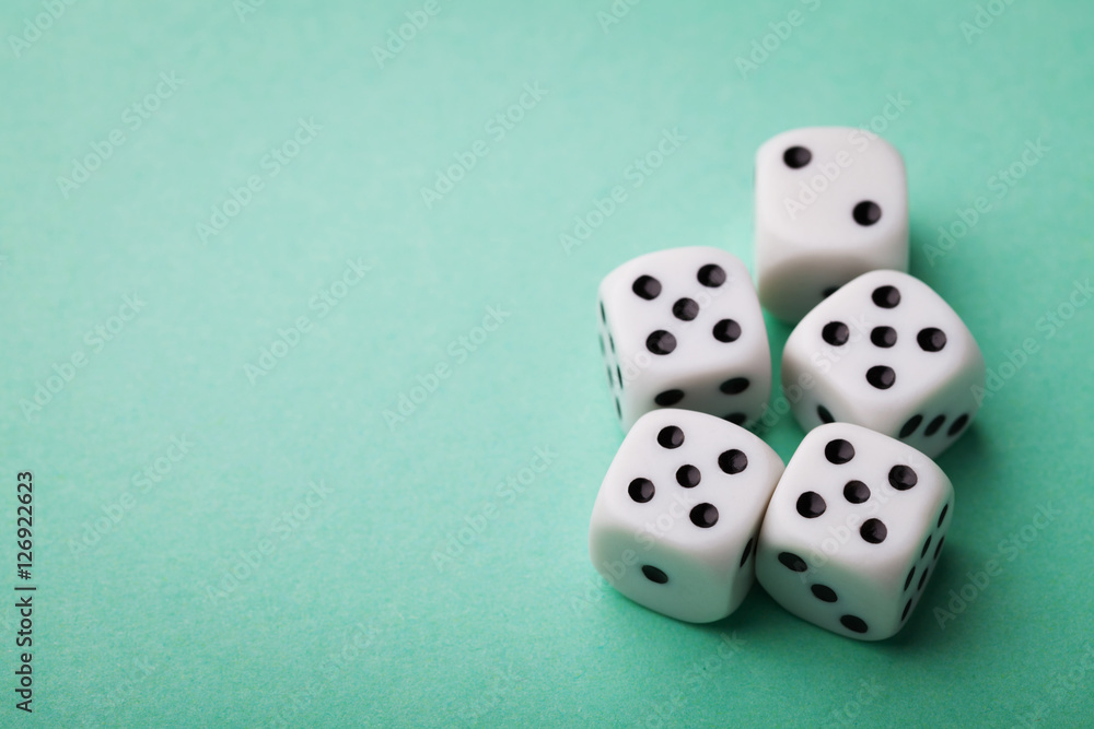 White dice on green table. Gambling devices. Copy space for text. Game of chance concept. White dice on green table. Gambling devices. Copy space for text. Game of chance concept.