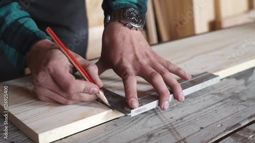 Male hands with ruler and pencil closeup. Professional carpenter at work.