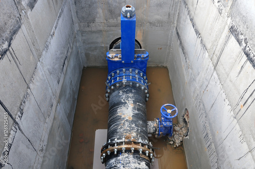 The construction process of node to connect cold water supply. The concrete box with a distribution pipe and valves. photo