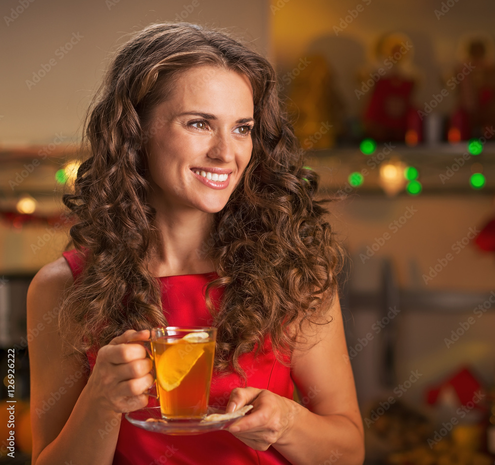 Happy young woman with cup of ginger tea looking on copy space Happy young woman with cup of ginger tea looking on copy space
