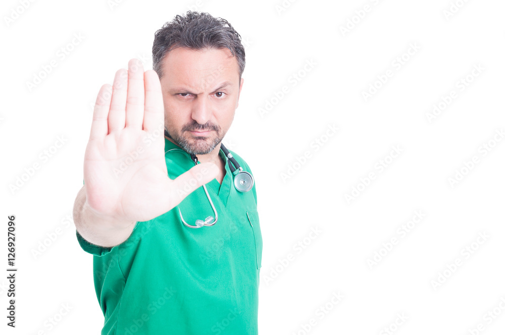 Serious male doctor doing stop gesture with hand Serious male doctor doing stop gesture with hand