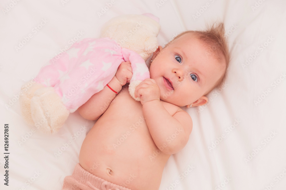 baby girl with mohawk hairstyle playing with teddy bear baby girl with mohawk hairstyle playing with teddy bear