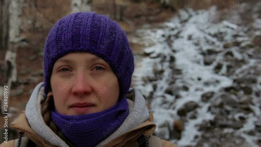 Portrait of a girl near a mountain stream in winter forest. Close-up Portrait of a girl near a mountain stream in winter forest. Close-up