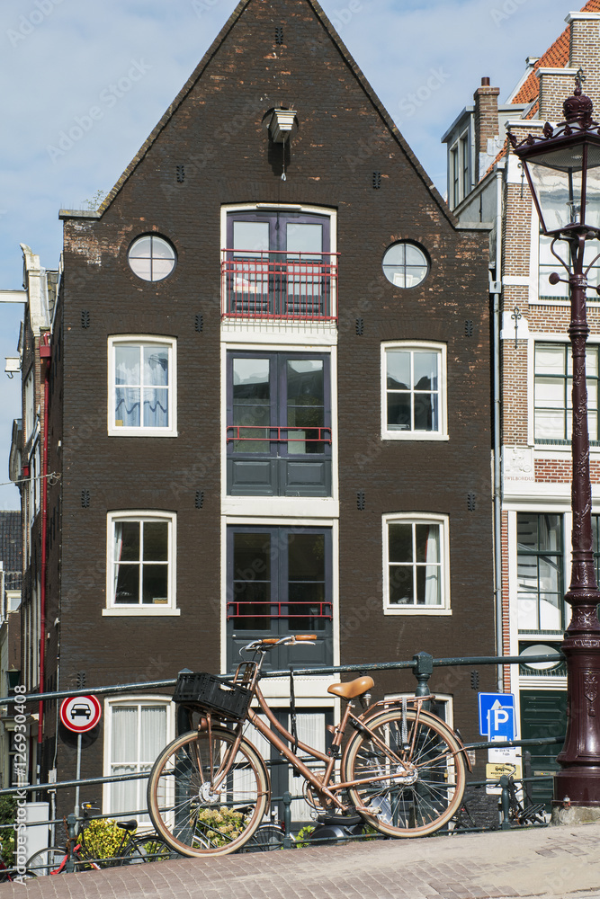 One brown bike on the pavement with old brown building as background