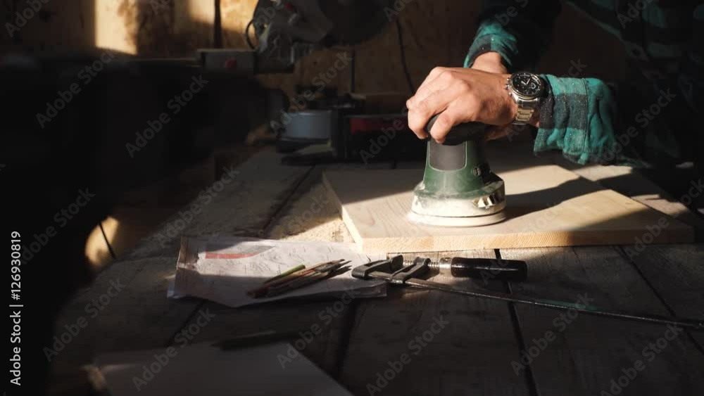 Carpenter grind wooden plank in his workshop Carpenter grind wooden plank in his workshop