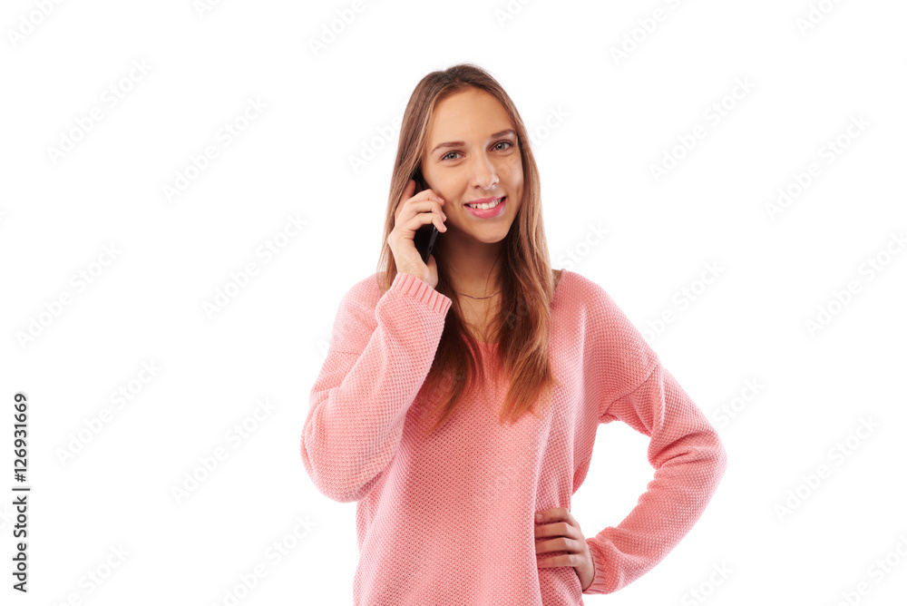 Cheerful Caucasian teenage girl smiling while talking on cellpho Cheerful Caucasian teenage girl smiling while talking on cellpho