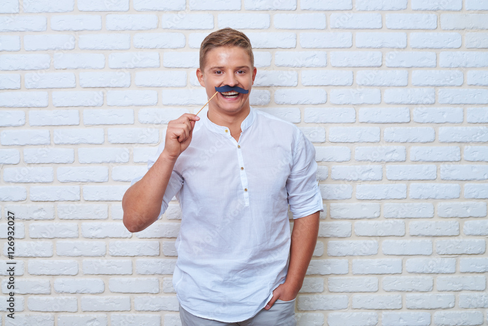 Portrait of handsome male in casual clothes wearing black paper Portrait of handsome male in casual clothes wearing black paper