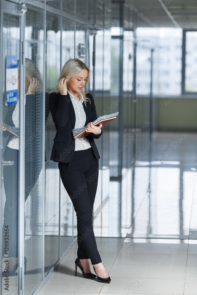 beautiful young businesswoman looking documents in the office. beautiful young businesswoman looking documents in the office.
