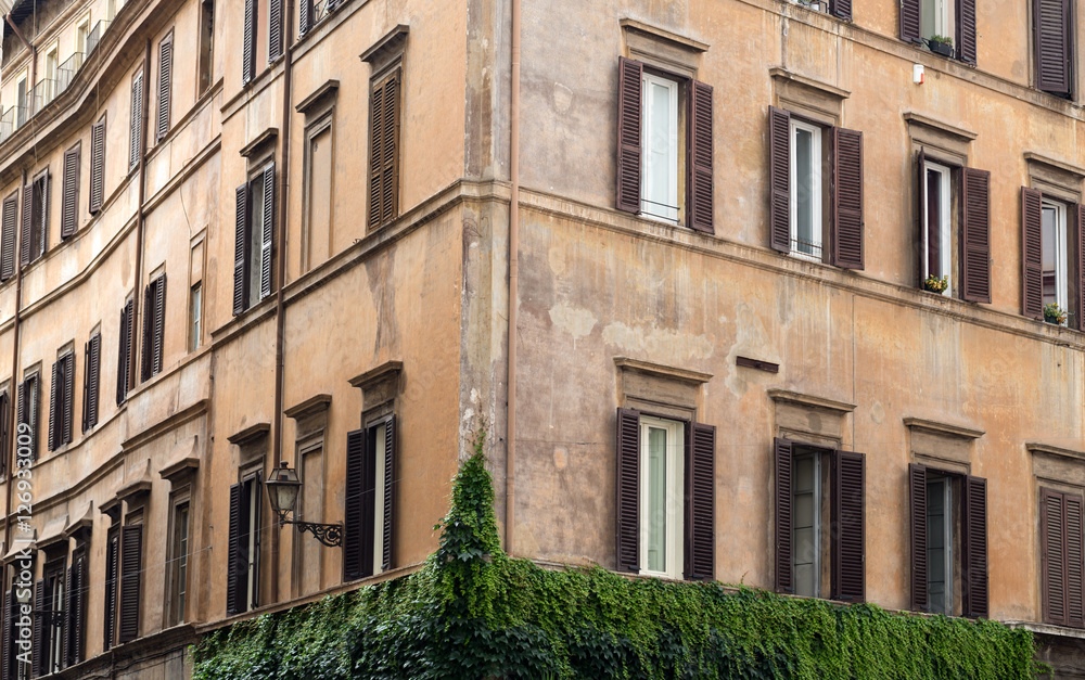 Fototapeta premium Old orange corner house in the center of Rome, Italy