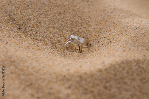 white gold wedding rings on the sand