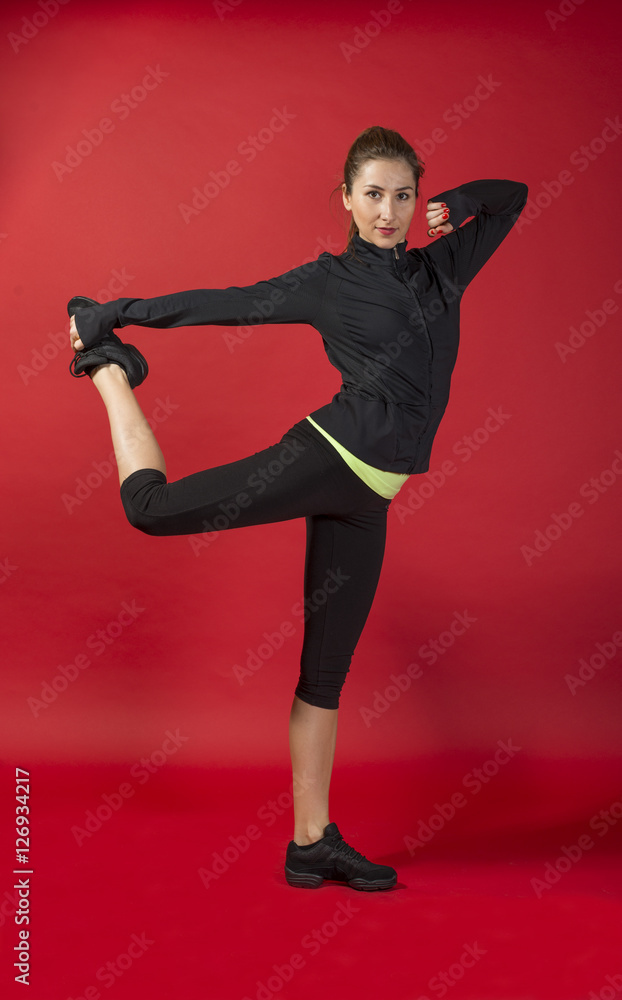 Beautiful sporty woman doing exercise. Woman exercising workout fitness aerobic exercise posture on studio over red background