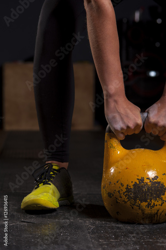 Sporty woman exercising with kettlebell in gym